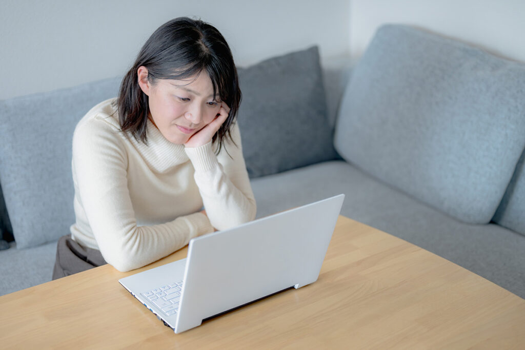 PCをみて悩む女性のイメージ