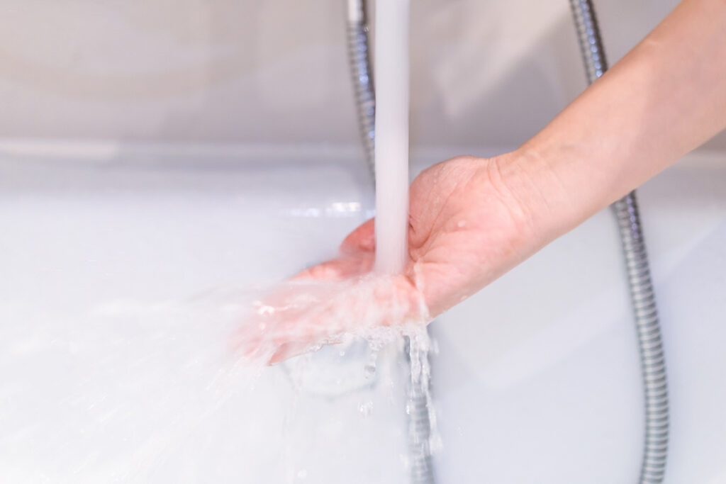 蛇口から出るお湯に触れるイメージ